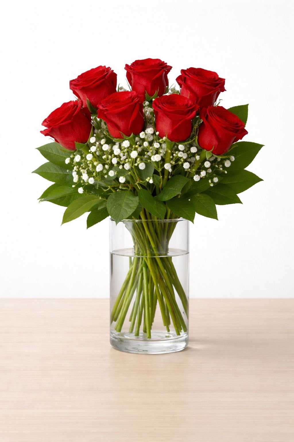Seven red roses with white baby's breath and greenery in a glass vase – Red Romance by Raindrops Flower